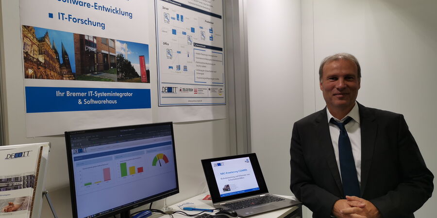 Abbildung 2: Messestand der DECOIT® GmbH mit CLEARER-Produkt und ScanBox-Plakat